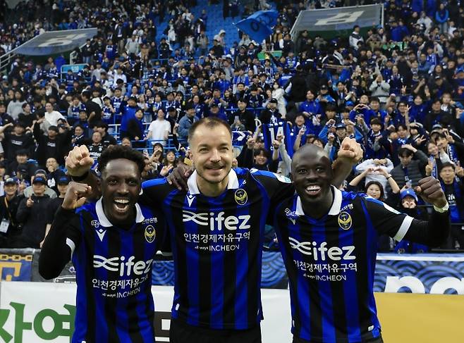 26일 오후 인천시 중구 도원동 인천축구전용경기장에서 열린 하나은행 K리그2 2025 36라운드 인천유나이티드와 경남FC의 경기에서 3대 0으로 승리, 우승을 확정하며 강등 1년 만에 다이렉트 승격을 이룬 인천 제르소(왼쪽부터), 무고사, 바로우가 서포터즈들과 기념 촬영을 하고 있다. 2025.10.26/뉴스1