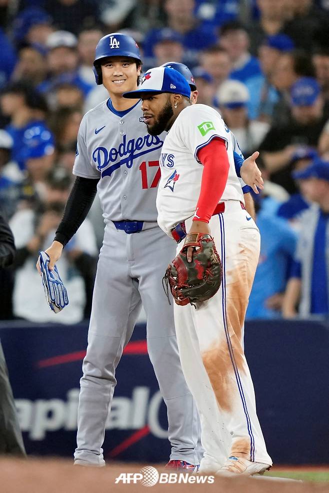 오타니 쇼헤이(왼쪽)가 29일(한국 시각) 캐나다 온타리오주에 위치한 로저스 센터에서 펼쳐진 2025 미국 프로야구 메이저리그(MLB) 포스트시즌 월드시리즈(7전 4선승제) 1차전에서 9회 블라디미르 게레로 주니어와 인사를 나누고 있다. /AFPBBNews=뉴스1