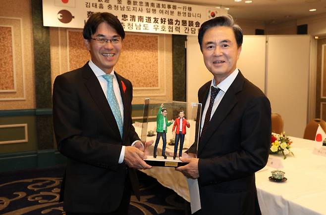 김태흠 충남지사와 야마시타 마코토 나라현 지사가 24일 나라현 나라 100년 회관에서 피규어를 들고 기념촬영을 하고 있다.[사진=충남도 제공]