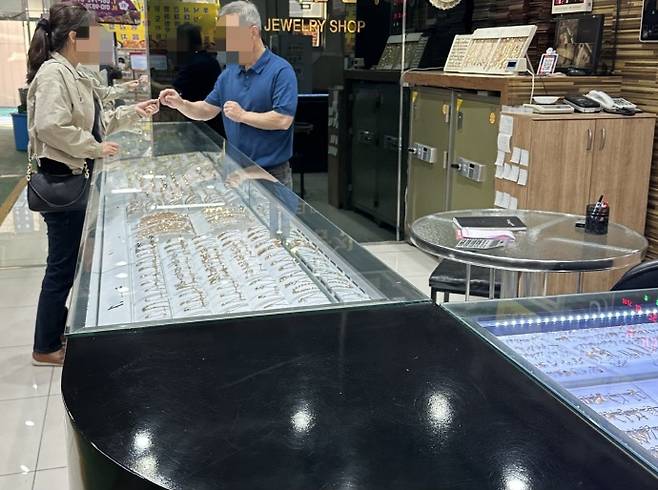 지난 25일 오후 전남 광양에 위치한 한 금은방에서 한 시민이 금은방 관계자로부터 금 관련 제품에 대해 설명을 듣고 있다./박준호 기자 bjh@namdonews.com