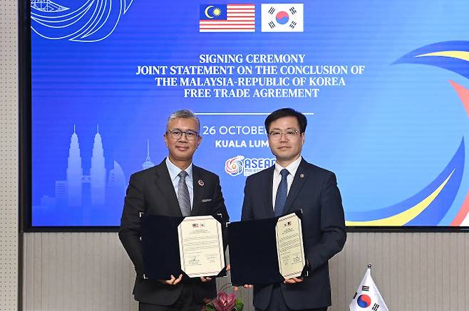 여한구 산업통상부 통상교섭본부장(오른쪽)과 뜽쿠 자프룰 말레이시아 투자통상산업부 장관이 지난 26일(현지시간) 말레이시아 쿠알라룸푸르 국제컨벤션센터(KLCC)에서 한-말레이시아 자유무역협정(FTA) 타결 공동선언문 서명식에서 기념촬영하고 있다. (사진=산업부)