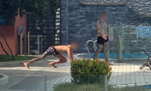 26일 오후(현지시간) 한국 청년들이 갇혀있는 것으로 추정되는 캄보디아 프놈펜의 한 고급 아파트단지에서 문신이 가득한 남성들이 체력 단련을 하고 있다.  [프놈펜(캄보디아)=연합뉴스]