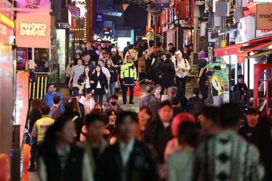 1년 전인 지난해 10월 25일. 이태원 골목에서 인파 사이로 경찰관이 현장을 지키고 있다. [뉴스1]