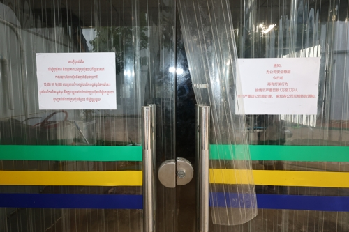 지난 22일(현지시간) 캄보디아 프놈펜 외곽에 위치한 한 범죄단지 건물에 크메르어와 중국어로 벌금 관련 안내문이 붙어있다. [연합뉴스]