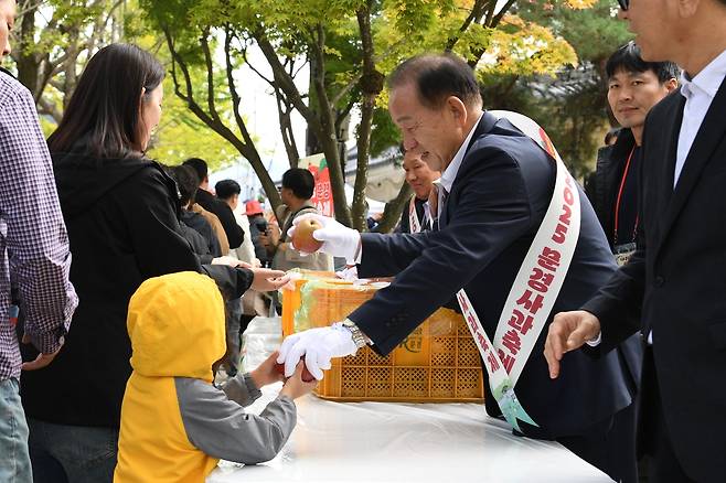 신현국 문경시장이 2025 문경사과축제 기간 중 사과를 나눠주고 있다.[문경시 제공]