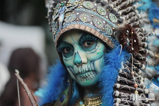 [멕시코시티=AP/뉴시스] 26일(현지 시간) 멕시코 수도 멕시코시티에서 해골 분장을 사람들이 연례 망자의 날 ‘카트리나 퍼레이드’에 참가하고 있다. '죽은 자들의 날'은 매년 10월 31일부터 11월 2일까지 죽은 이들을 기리는 멕시코 명절이다. 멕시코인들은 세상을 떠난 이들이 1년에 한 번 가족과 친구를 만나러 세상에 내려온다고 믿어 10월 말일에 제단을 마련한 뒤 11월 1일에는 죽은 아이들을, 11월 2일에는 죽은 어른들을 위해 기도를 올린다. 2025.10.27.