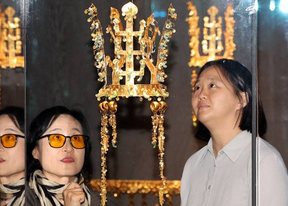 104년 만에… 에이펙 빛내는 신라 금관 27일 국립경주박물관에서 열린 아시아태평양경제협력체(APEC)·개관 80주년 기념 특별전 ‘신라 금관, 권력과 위신’ 특별전 미디어데이 참석자들이 국보인 신라시대 황남대총 금관을 바라보고 있다. 이번 특별전은 신라 금관이 세상에 처음 알려진 지 104년 만에 6점의 금관이 한자리에 모여 전시되는 첫 행사다. 경주=뉴스1