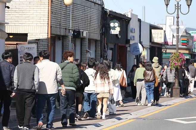 줄지어 이동하는 관광객들  (경주=연합뉴스) 박세진 기자 = 2025 경주 아시아태평양경제협력체(APEC) 정상회의 주간 시작일인 27일 경주 황금동 황리단길이 외국인 등 관광객으로 붐비고 있다. 2025.10.27 psjpsj@yna.co.kr