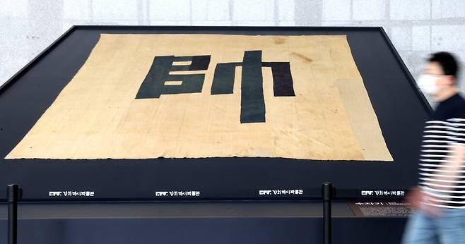 ▲ 신미양요 150주년을 맞아 인천강화역사박물관에서 열리고 있는 '수자기(장수깃발) 특별전'을 찾은 관람객이 수자기를 살펴보고 있다. 수자기는 깃발 한가운데 장수를 뜻하는 '수(帥)'자가 적혀 있는 대형 깃발로 총 지휘관이 있는 본영에서 사용했다. 깃발은 삼베재질로 만들어 졌으며 현존하는 유일한 장수기이다. /양진수 기자 photosmith@incheonilbo.com