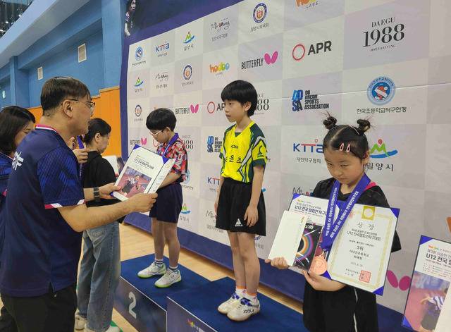 경북 봉화 상운초등학교 2학년 김아영 선수가 지난 28일 밀양시 배드민턴경기장에서 열린 '제3회 유승민 전 IOC위원배 U12 전국 챔피언 탁구대회'에서 1~2학년부 여자 개인 단식 우승을 차지한 뒤 시상식에서 금메달을 받고 있다. 상운초등학교 제공