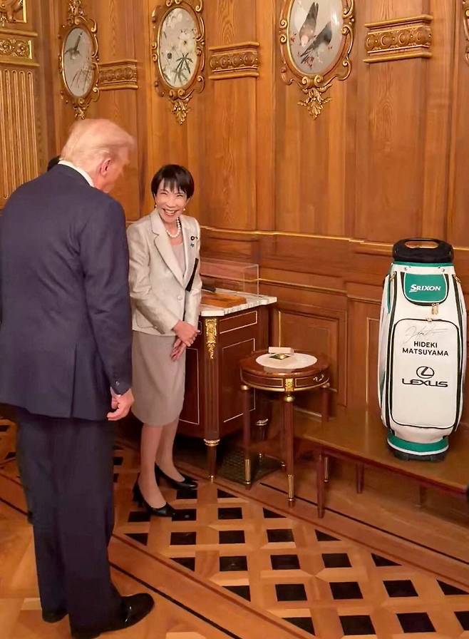 28일 일본 도쿄에서 고(故) 아베 신조 전 총리가 소유했던 퍼터, 마츠야마 히데키의 사인이 들어간 캐디백, 금박 골프공을 도널드 트럼프 미국 대통령에게 선물하는 다카이치 사나에 일본 총리의 모습./로이터 연합뉴스