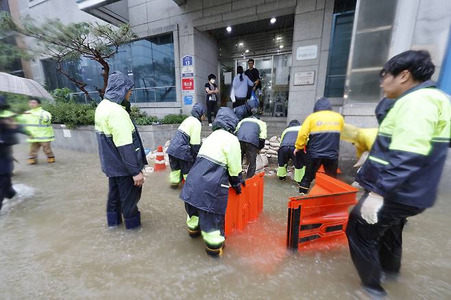 호우경보가 발효된 17일 광주 남구 백운동 일대 상가가 침수되자 공무원들이 한 건물입구서 빗물 침수 차단작업을 하고 있다. 2025.7.17 (ⓒ뉴스1, 무단 전재-재배포 금지)