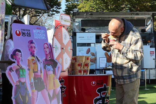 2025 경주 아시아태평양경제협력체(APEC) 정상회의 주간 시작 첫날인 지난 27일 경북 경주 APEC 국제미디어센터 인근 K-푸드 홍보관에 마련된 농심 부스에서 한 외국인이 시식을 하고 있다. /사진=최혁 기자