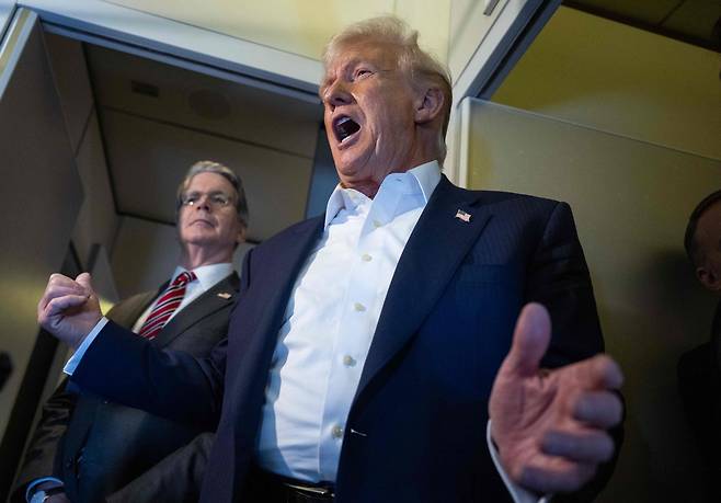 도널드 트럼프 미국 대통령(왼쪽)이 27일(현지시간) 일본으로 향하는 스콧 베선트 미 재무장관이 에어포스원을 타고 언론과 대화하는 모습을 지켜보고 있다. [AFP]