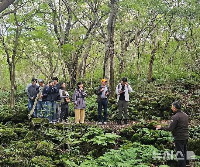 [제주=뉴시스] 마크 크리거 스위스 동부 응용과학대학(OST) 교수 등이 지난 23일 제주시 교래곶자왈을 방문해 식생과 지형 등을 살펴보고 있다. (사진=김장훈 천리포수목원 전문위원 제공)  2025.10.28. photo@newsis.com