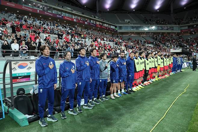 홍명보 축구대표팀 감독(왼쪽 아래)이 지난 10월 14일 서울월드컵경기장에서 열린 파라과이와 평가전을 앞두고 코칭스태프, 선수들과 함께 국민의례를 하고 있다. 연합뉴스