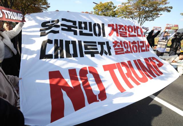 29일 오후 한미 정상회담이 열린 국립경주박물관 인근에서 도널드 트럼프 미국 대통령을 반대하는 기습 시위대가 현수막을 펼쳐들고 있다. 연합뉴스