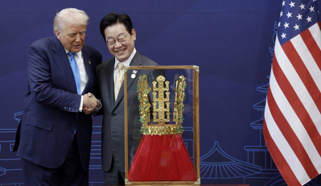 도널드 트럼프 대통령을 위해 1천g의 금을 들여 특별 제작한 '천마총 금관 모형'과 웃으며 손잡은 한미 정상. 이재명 대통령이 29일 경북 경주박물관에서 트럼프 대통령에게 '천마총 금관 모형'을 선물했다. 대통령실통신사진기자단, 연합뉴스