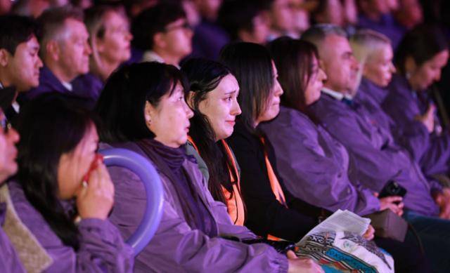 안나(주황색 조끼)는 25일 서울시청 광장에서 외국인 희생자 유가족들이 참여한 이태원 참사 3주기 시민추모대회에서 통역 등을 맡았다. 안나가 추모 행사를 보다가 눈물을 흘리고 있다. 연합뉴스