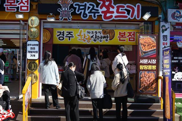 국내외 관광객들이 28일 십원빵을 맛보기 위해 경주 황리단길의 한 매장에서 줄을 서고 있다. 경주=김재현 기자