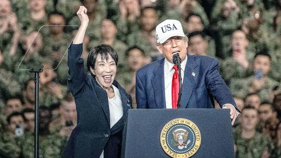 28일 미 대통령 전용 헬기인 마린원을 타고 일본 요코스카 미 해군기지를 함께 방문한 다카이치 사나에 일본 총리가 도널드 트럼프 대통령의 소개에 손을 들어보이며 인사하고 있다. 로이터=연합뉴스