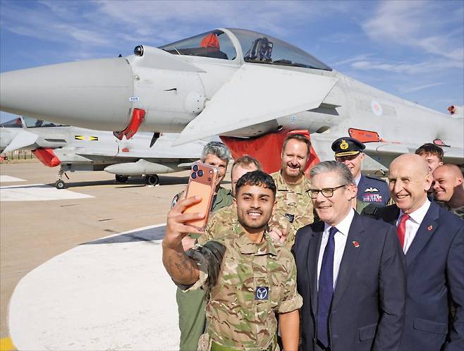 < 스타머, 유로파이터 앞 기념사진 > 키어 스타머 영국 총리(앞줄 가운데)와 존 힐리 국방부 장관(오른쪽)이 27일(현지시간) 튀르키예 앙카라의 투사스 공군기지에서 영국 공군 장병들과 함께 유로파이터 타이푼 전투기를 배경으로 사진을 찍고 있다.   로이터연합뉴스