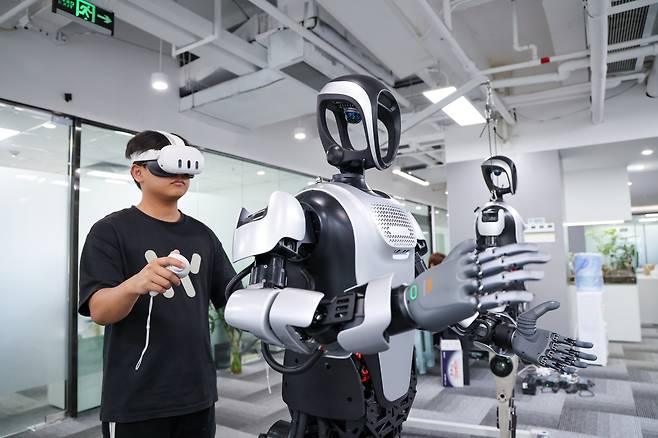 A staff member adjusts humanoid robot Kuavo at Leju Robotics in Shenzhen in China's Guangdong Province, on March 27. [XINHUA/YONHAP]