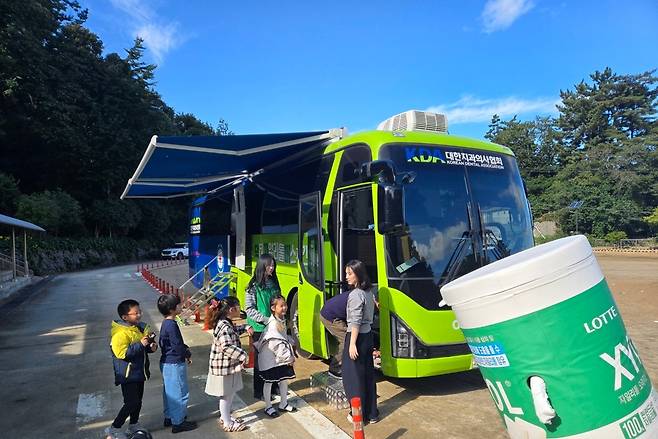 경북 울릉군 천부초 학생들이 이동치과병원 ‘닥터자일리톨 버스’를 타기 위해 줄지어 서 있다.  정석준 기자