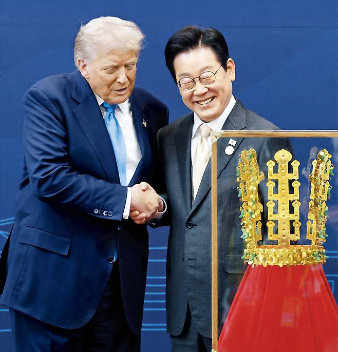 이재명 대통령(오른쪽)과 도널드 트럼프 미국 대통령이 29일 한미 정상회담에서 신라 천마총 금관 모형 앞에서 악수를 하고 있다. /뉴시스