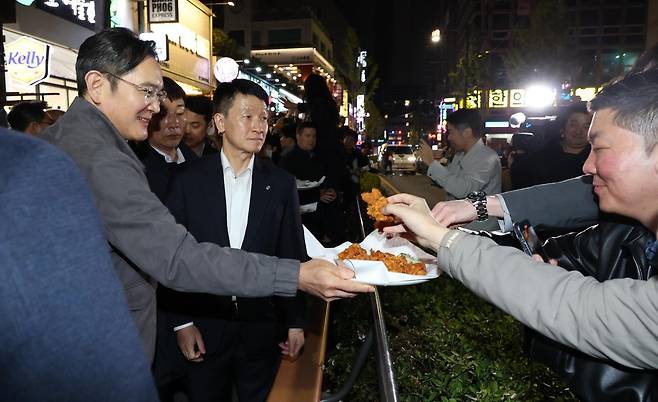 이재용 삼성전자 회장이가 30일 서울 강남구 깐부치킨 삼성점에서 젠슨황 엔비디아 최고경영자와 ‘치맥’ 회동 중 시민들에게 치킨을 나눠주고 있다.