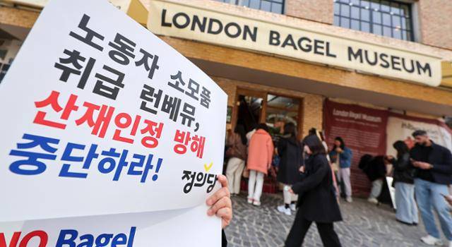 30일 서울 종로구 런던베이글뮤지엄 매장 앞에서 정의당 관계자가 '직원 과로사 사건'에 항의하는 손피켓을 들고 있다. 뉴스1
