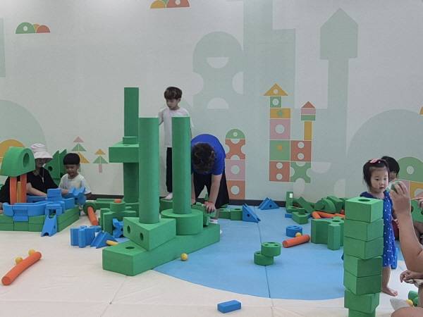 안데르센 이야기관 체험시설인 ‘미운오리의 여정’에서 보호자와 아이들이 미운 오리가 쉴 수 있는 집을 만들고 있다.