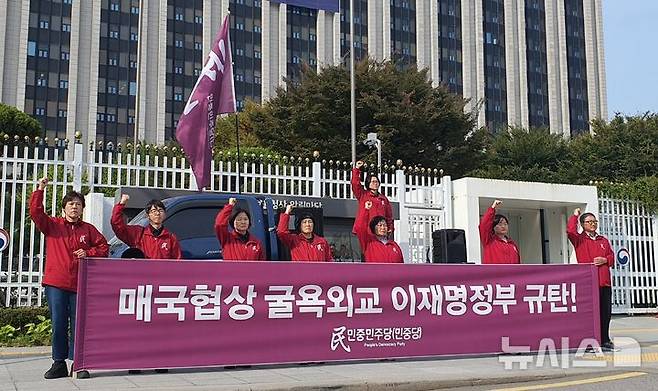 [서울=뉴시스] 김예겸 인턴기자 = 민중민주당(민중당) 관계자가 30일 오전 서울 종로구 정부서울청사 앞에서 매국협상타결 이재명 정부 규탄 정당연설회를 열고 구호를 외치고 있다. 이들은 아시아·태평양경제협력체(APEC) 정상회의를 계기로 방한한 도널드 트럼프 미국 대통령에게 훈장과 금관을 상납했다며 자동차와 그 부품 관세를 15%로 인하하기로 합의한 한미무역협정은 성과가 아니라고 비판했다. 2025.10.30. photo@newsis.com