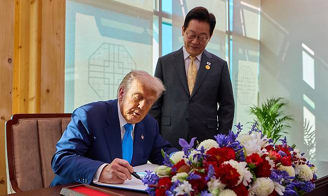 이재명 대통령이 지난 29일 한미 정상회담이 열리는 경북 경주박물관에서 도널드 트럼프 미국 대통령의 방명록 작성 모습을 보고 있다. 대통령실 제공