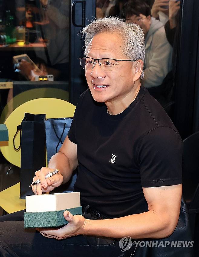 선물에 사인하는 젠슨 황 (서울=연합뉴스) 이진욱 기자 = 젠슨 황 엔비디아 최고경영자가 30일 오후 서울 삼성역 인근 치킨 매장에서 진행된 이재용 삼성그룹 회장, 정의선 현대차그룹 회장과의 회동 중 선물에 사인을 하고 있다. 2025.10.30 [공동취재] cityboy@yna.co.kr