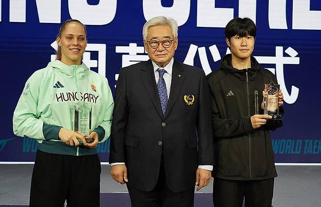 세계선수권대회에서 MVP를 받은 서은수(오른쪽) 태권도 국가대표 서은수(오른쪽)가 30일 중국 장쑤성 우시의 타이후 인터내셔널 엑스포 센터에서 열린 2025 세계태권도선수권대회 마지막 날 남자부 대회 최우수선수상(MVP)을 받은 뒤 포즈를 취하고 있다. 가운데는 조정원 세계태권도연맹 총재. [세계태권도연맹 제공. 재배포 및 DB금지]