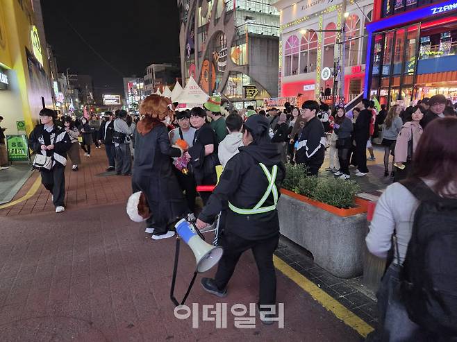31일 밤 홍대 레드로드에서 안전요원이 코스프레를 한 시민들에게 안전을 당부하고 있다. (사진=염정인 기자)
