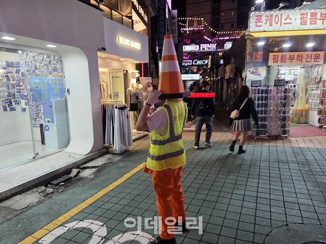 31일 밤 홍대 레드로드 거리 인근에서는 밝게 빛나는 경광봉을 든 안전요원 차림의 코스튬을 한 시민이 서 있었다. (사진=염정인 기자)