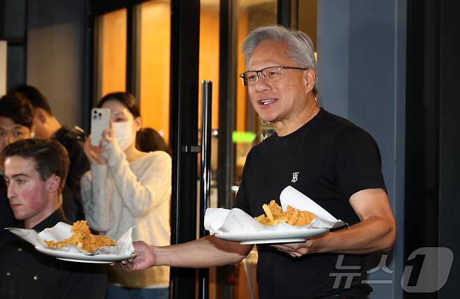 젠슬황 엔비디아 최고경영자가 30일 서울 강남구 깐부치킨 삼성점에서 이재용 삼성전자 회장과 정의선 현대차그룹 회장과 '치맥' 회동 중 시민들에게 치킨을 나눠주고 있다. (공동취재) 2025.10.30/뉴스1 ⓒ News1 김진환 기자