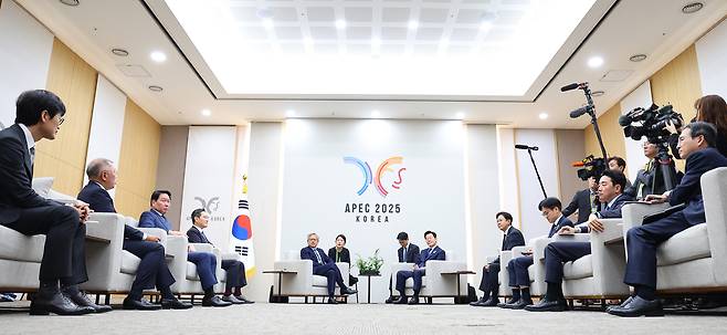 President Lee Jae-myung (center right), Nvidia CEO Jensen Huang (center left) and other conglomerate chiefs hold a meeting on the sidelines of the APEC Summit in Gyeongju, North Gyeongsang Province, Friday. From left are Naver founder Lee Hae-jin, Hyundai Motor Executive Chair Chung Euisun, SK Group Chair Chey Tae-won, Samsung Electronics Chair Lee Jae-yong, Huang, President Lee, and Science and ICT Minister Bae Kyung-hoon. (Yonhap)