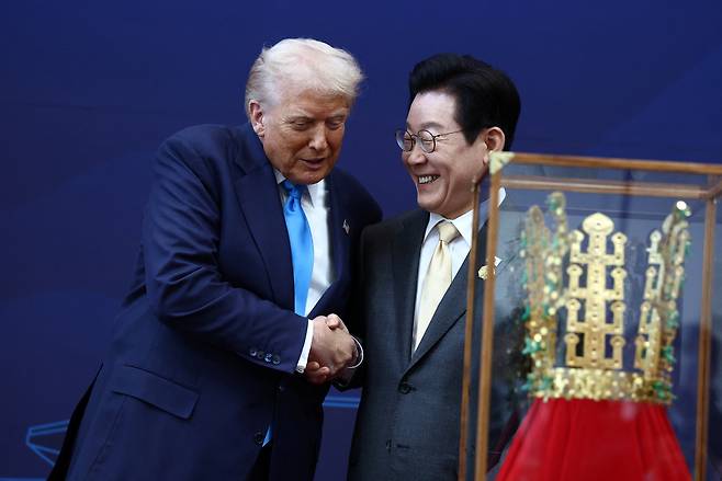 도널드 트럼프 미국 대통령이 29일 경주에서 열린 아시아태평양경제협력체(APEC) 정상회의에서 이재명 대통령으로부터 무궁화 훈장과 천마총 모양의 금관을 수여받고 있다. [로이터]