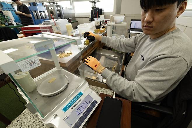 한국 금거래소 직원이 프레스로 찍어서 나온 10g 골드바의 무게를 측정하고 있다. 이 회사는 0.004~0.006g의 여유를 두고 살품을 만든다. 전민규 기자