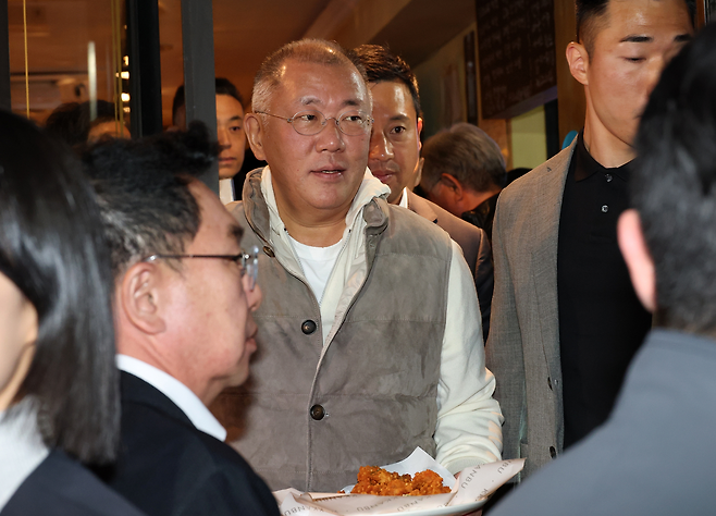 정의선 현대차그룹 회장이 지난 30일 서울 삼성동 한 치킨집에서 진행된 회동 중 시민에게 치킨과 감자튀김을 나눠주고 있다. [연합]