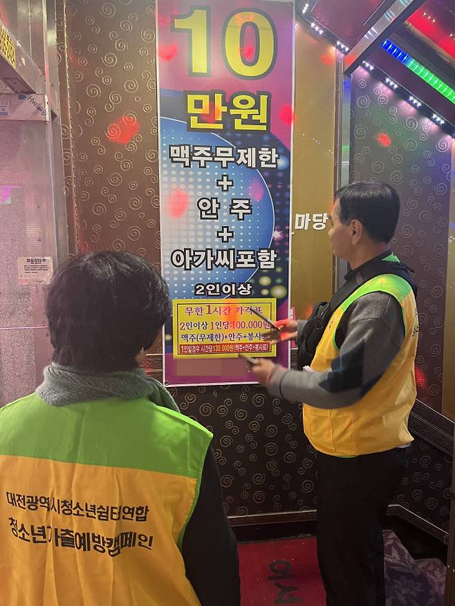 대전위기청소년지원네트워크 관계자들이 대전 신탄진역 앞 학생들 통학로에 있는 업소에 여성을 상품처럼 표현한 광고물을 모니터하고 있다. (사진=청소년지원네트워크 제공)