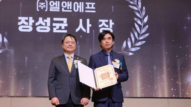 장성균 엘앤에프 CPO(오른쪽)가 지난달 30일 열린 '제5회 배터리 산업의 날' 기념식에서 산업포장을 받은 뒤 문신학 산업통상자원부 차관과 기념사진을 찍고 있다. 엘앤에프 제공