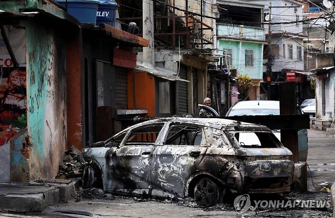 28일(현지시간) 브라질 갱단 해체 작전지 내 불에 탄 자동차 [연합]