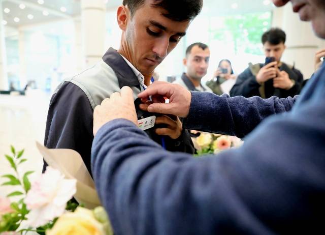 키롬 살로히딘 주한 타지키스탄 대사가 지난달 22일 인천국제공항에서 타지키스탄 국적 우빈 씨의 가슴에 이름표를 달아주고 있다. 사진 제공=산업인력공단