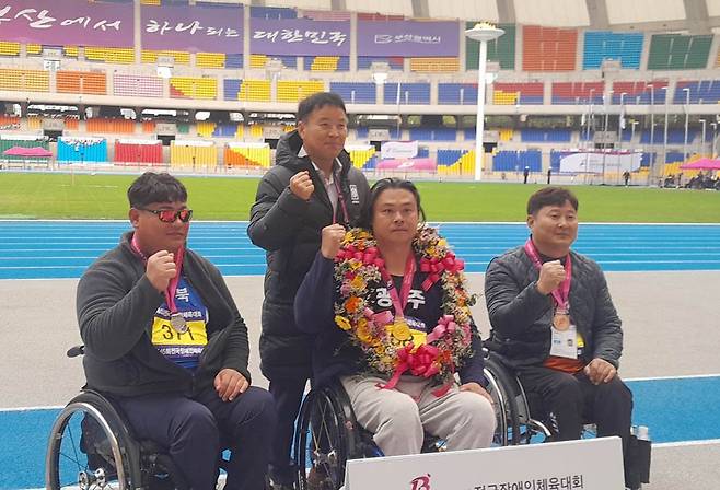 3일 열린 육상 창던지기에서 금메달을 수확하며 대회 3관왕에 오른 정대광(가운데)이 시상식에서 파이팅을 외치고 있다. <광주시장애인체육회 제공>