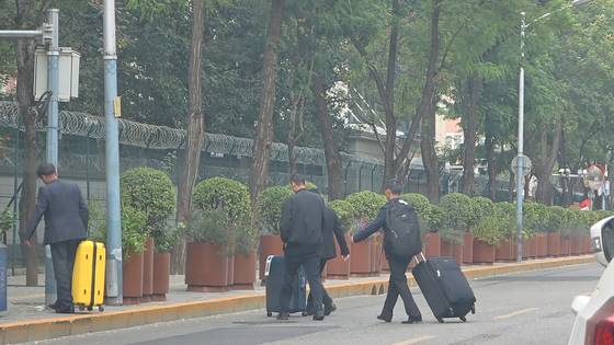 중국 베이징 북한쇼핑거리에서 대형 여행용 가방을 끌고 나온 북한대사관 관계자들 모습. 사진 이도성 특파원.