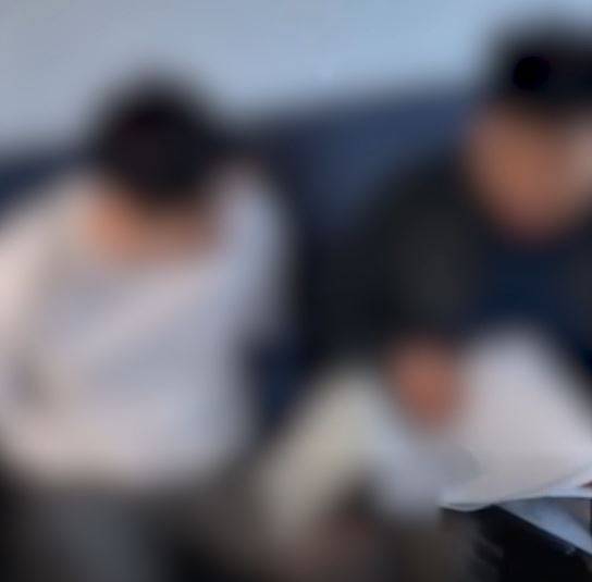 A cyber investigator, right, from the Gyeonggi Nambu Provincial Police Agency reads the Miranda warning and executes an arrest and search warrant on a member of a hacking and phishing ring. [GYEONGGI NAMBU PROVINCIAL POLICE AGENCY]